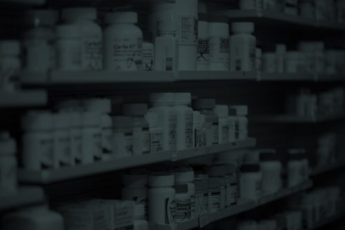 a dark image of medicine bottles on a shelf