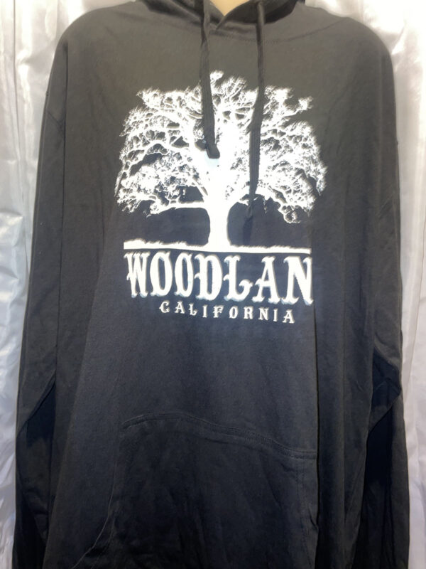 A black hooded pullover sweatshirt with a white Woodland logo featuring a silhouette of a large tree