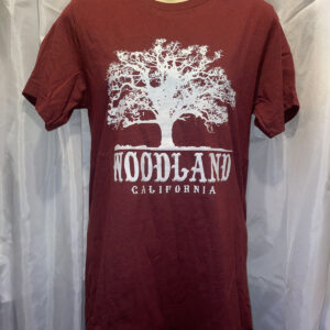 A burgundy t-shirt with a large white Woodland logo featuring a silhouette of a tree